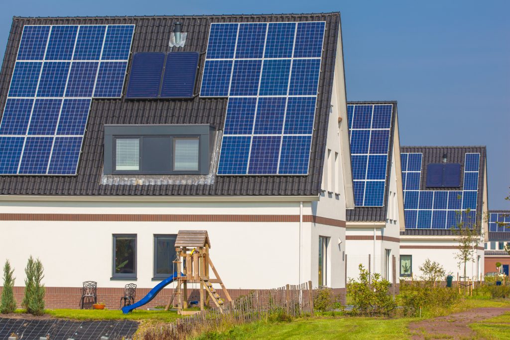 Mehrere Einfamilienhäuser mit Photovoltaikanlagen auf den Dächern in einer Wohnsiedlung