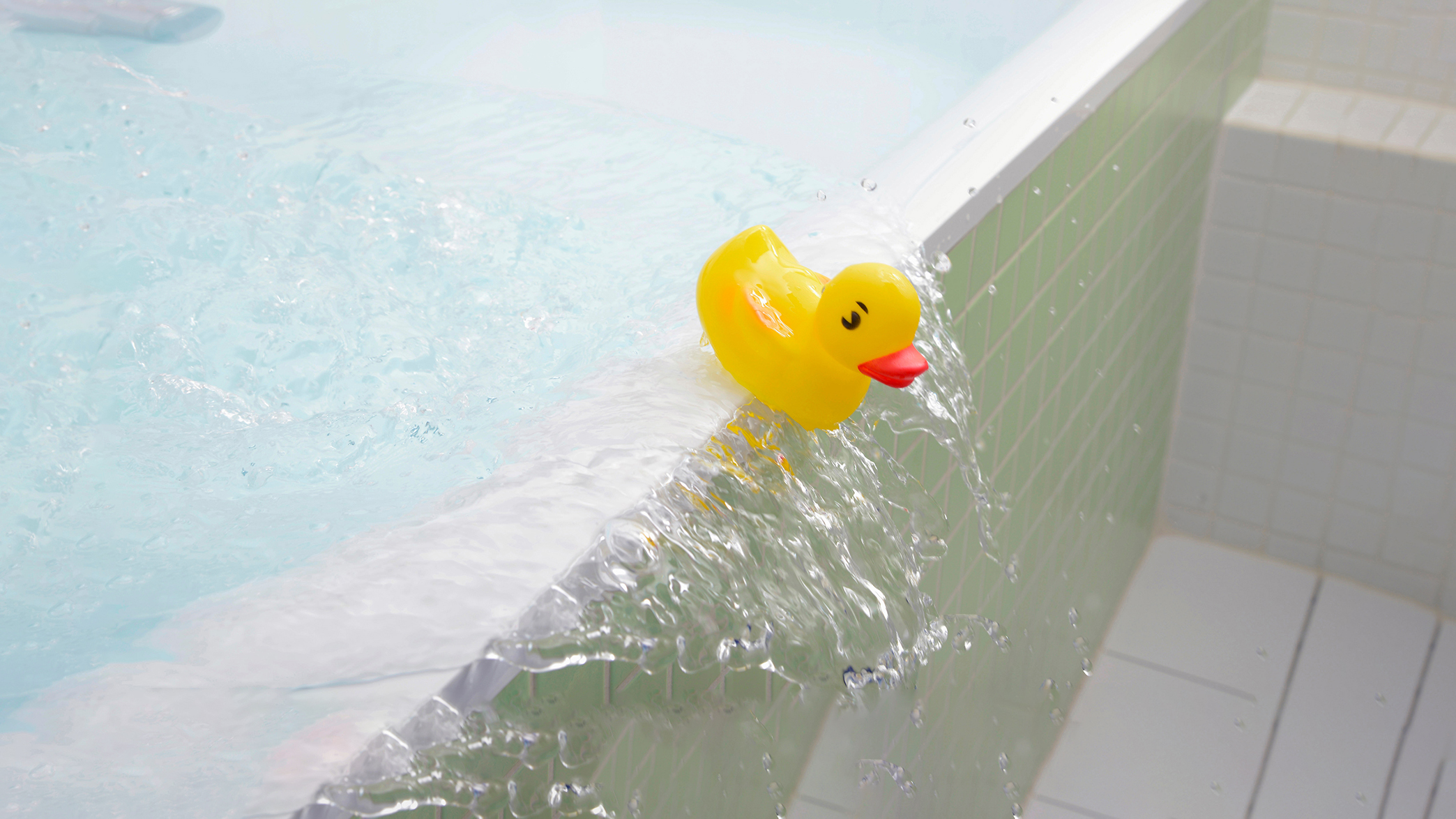 Badewanne mit Wasser läuft über. Quietcheentchen im Bild