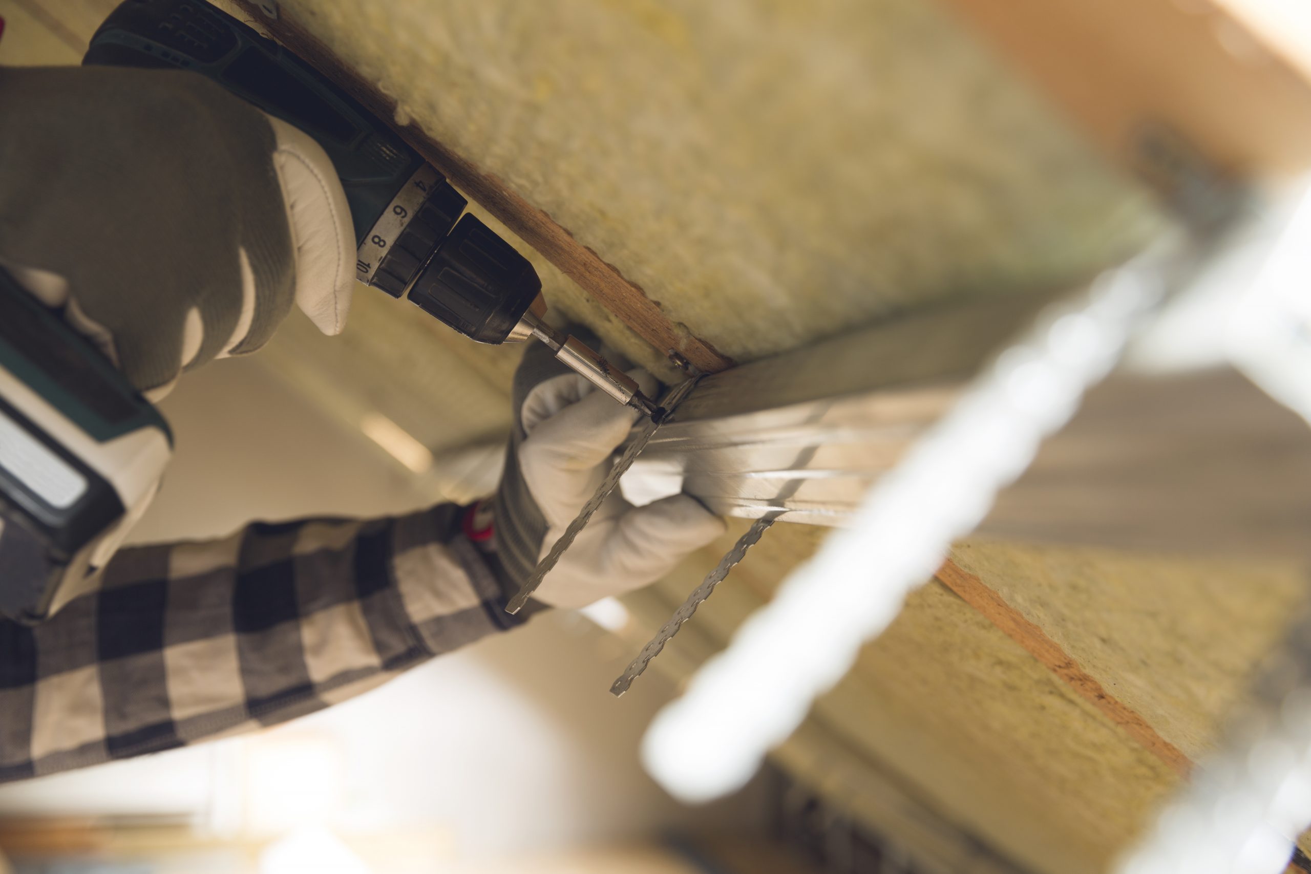 Mann, thermische Dach Dämmschicht installieren - mit Mineralwolle-Platten. Dachboden Renovierung und Dämmung Konzept