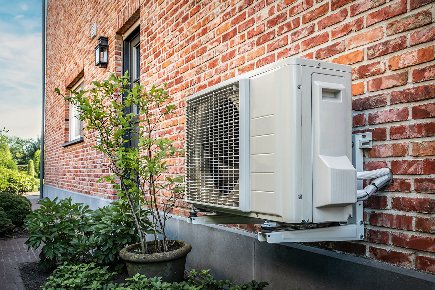 Installierte Außenunit einer Luftwärmepumpe an der Hauswand – energieeffiziente Heiztechnik für moderne Gebäude.