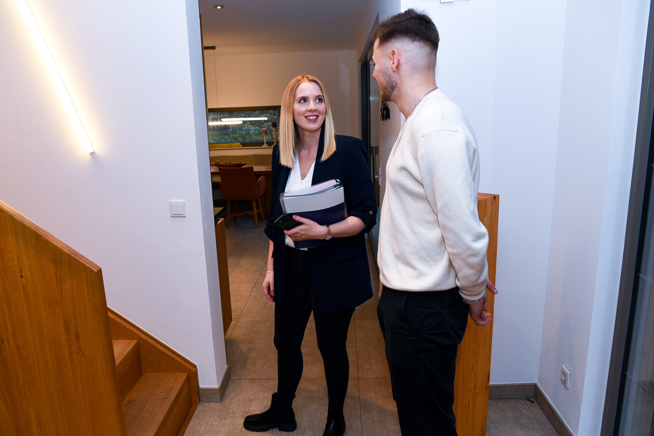 Immobilienmaklerin zeigt einem jungen Mann ein Haus